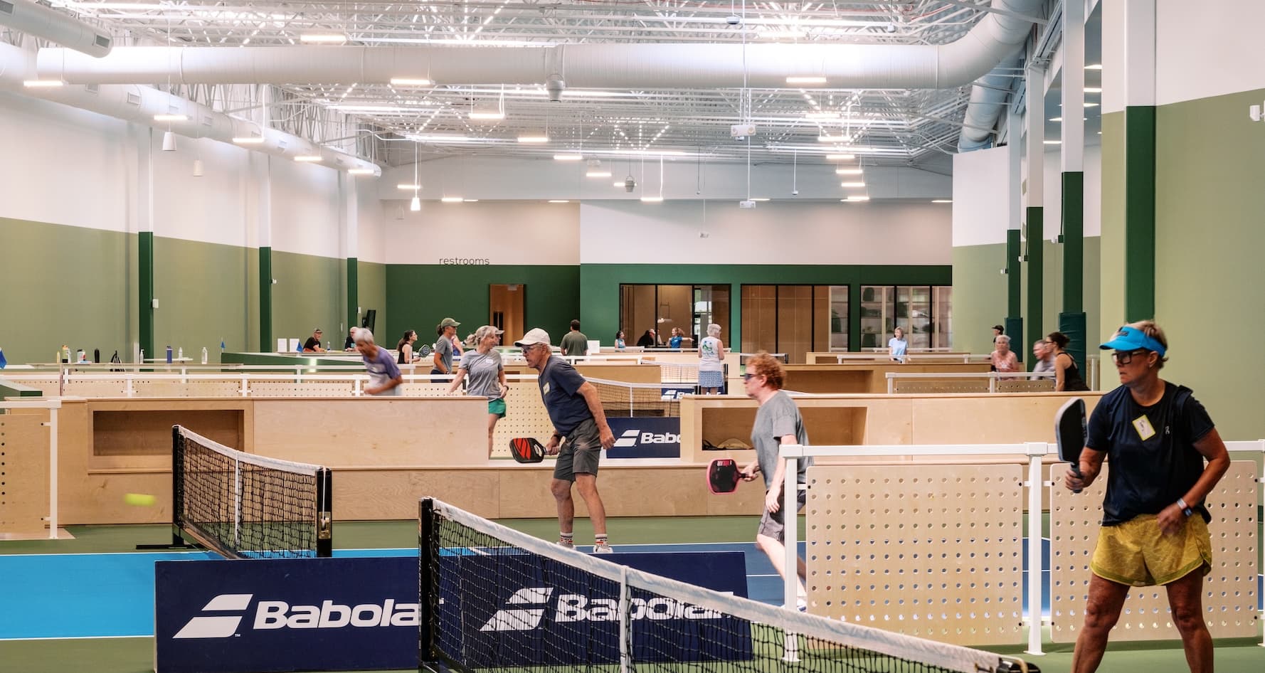 Players on the courts at an indoor pickleball facility